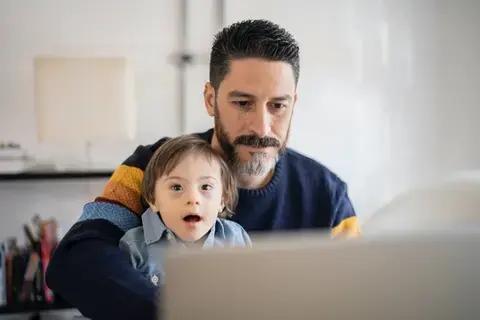 Father and son on laptop.